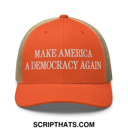 Orange and beige mesh trucker hat with white embroidered text make america a democracy again