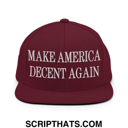 Maroon snapback hat with white embroidered make america decent again text and flat bill brim design