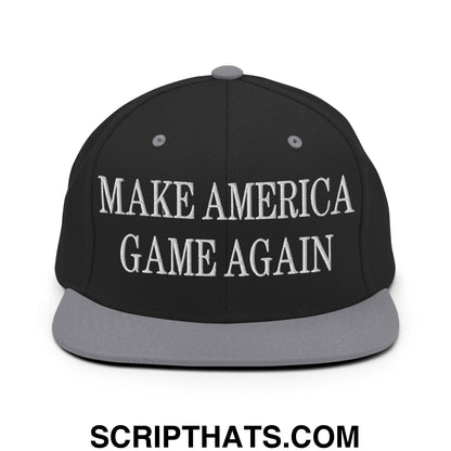 Black snapback cap with gray flat bill and white embroidered make america game again text on front panel