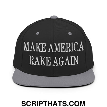 Black snapback cap with gray brim and white embroidered make america rake again text flat bill brim snapback hat