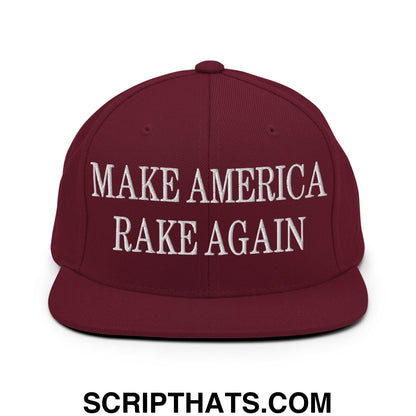 Maroon snapback hat with white embroidered make america rake again text and flat bill brim design