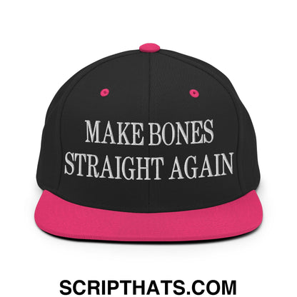 Black snapback cap with vibrant pink brim and button featuring white embroidered text reading make bones straight again