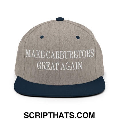 A gray and navy blue snapback hat with white embroidered text make carburetors great again and a flat bill brim