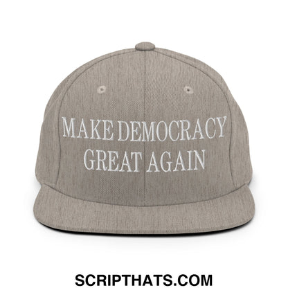 Gray snapback cap with white embroidered make democracy great again text and a flat bill brim design