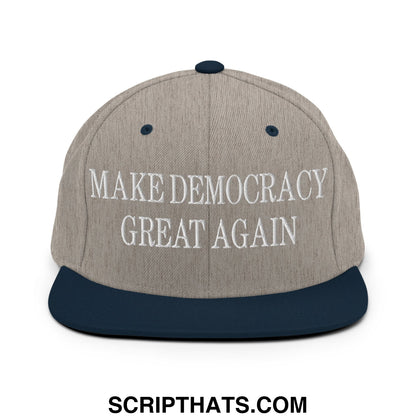 A gray and navy blue snapback hat with make democracy great again embroidered in white on the front panel