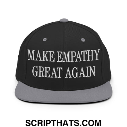 Black snapback cap with gray brim and white embroidered text make empathy great again on front panel
