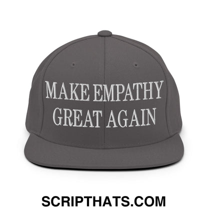 A dark gray snapback hat with a flat bill brim featuring white embroidered make empathy great again text