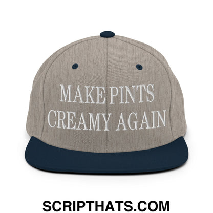 A gray and navy blue snapback hat with white embroidered make pints creamy again text and a flat bill brim