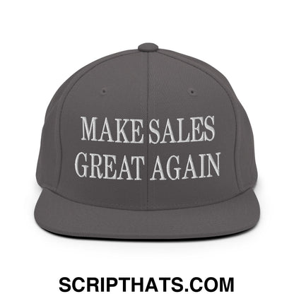 A dark gray snapback hat with a flat bill brim featuring white embroidered text make sales great again