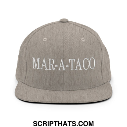 A gray heathered snapback hat with white embroidered mar-a-taco lettering and a flat bill brim