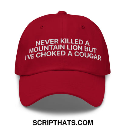 A vibrant red unstructured dad hat with white embroidered text reading never killed a mountain lion but ive choked a cougar