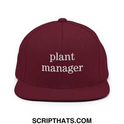 Maroon snapback hat with flat bill brim and white embroidered plant manager text on the front panel