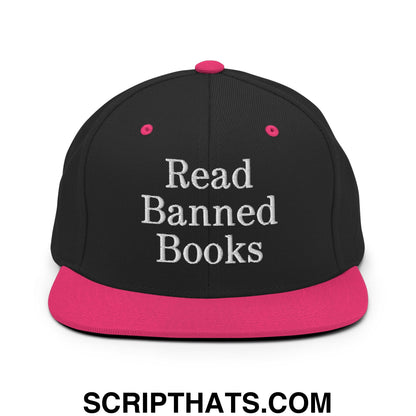 Black snapback hat with vibrant pink brim and button embroidered with read banned books in white
