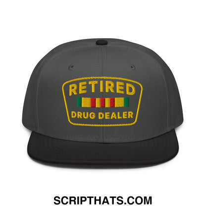 Dark gray snapback cap with black brim and yellow embroidered patch reading retire above colorful stripes drug dealer text