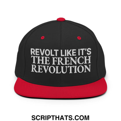 Black snapback hat with red brim and white embroidered text reading revolt like it s the french revolution
