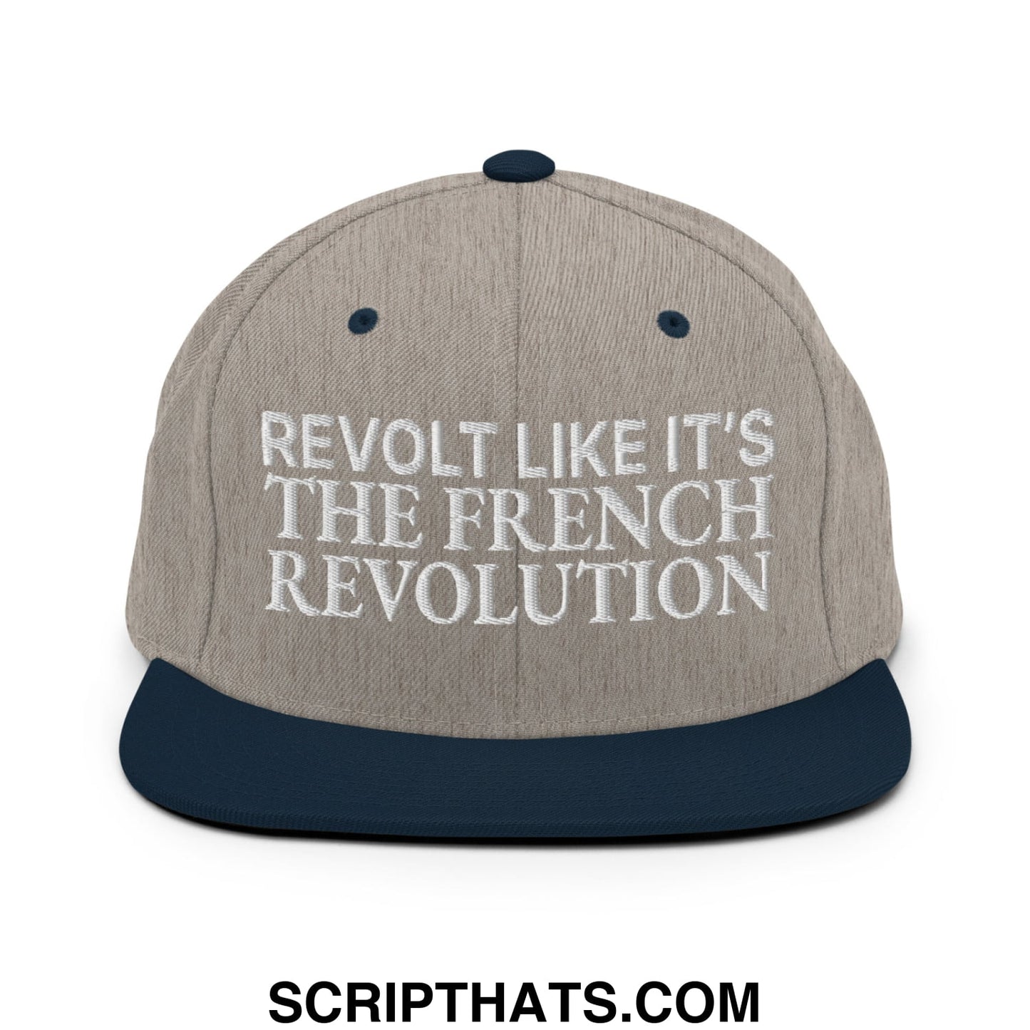 Beige and navy blue snapback cap with white embroidered text reading revolt like it’s the french revolution