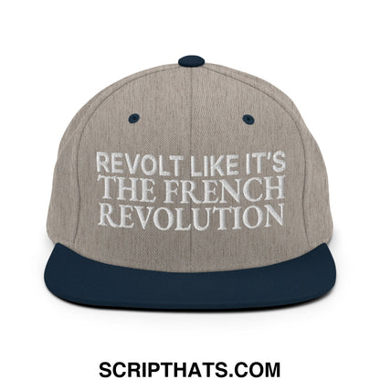 Beige and navy blue snapback cap with white embroidered text reading revolt like it’s the french revolution