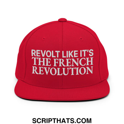 Red snapback hat with flat bill brim featuring white embroidered text revolt like it’s the french revolution