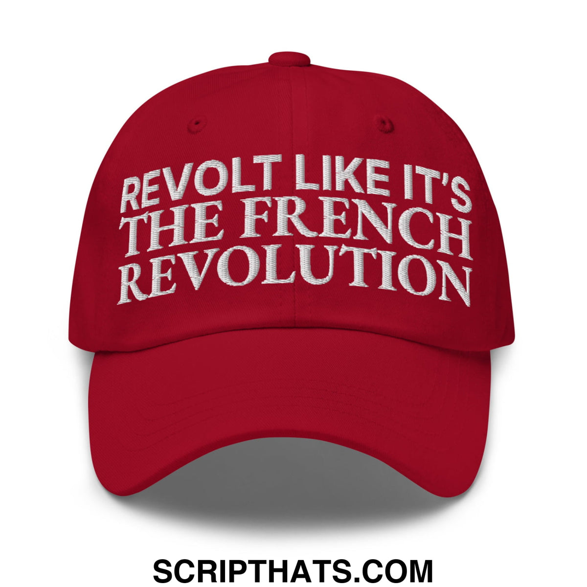 A vibrant red unstructured dad hat with white embroidered text reading revolt like it’s the french revolution