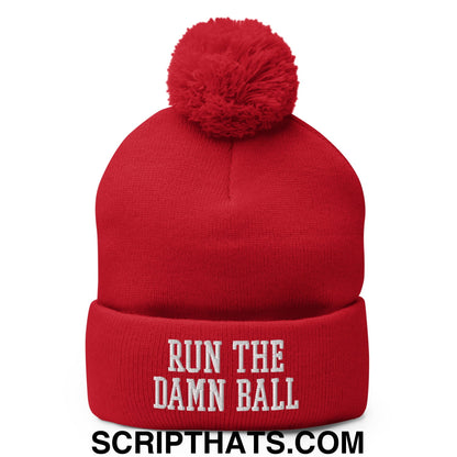 Red knit beanie with a fluffy pom pom and white embroidered run the damn ball text on the cuff