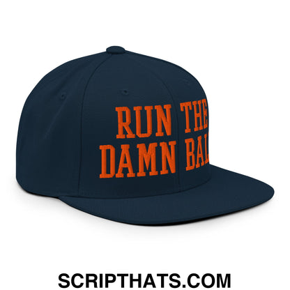 Navy blue snapback hat with bold orange embroidered run the damn ball text and flat bill brim design