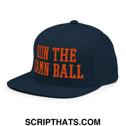 Navy blue snapback hat with bold orange embroidered run the damn ball text and flat bill brim design