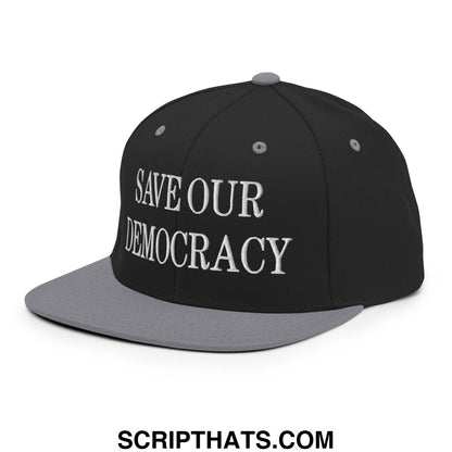 Black and gray snapback cap with white embroidered save our democracy text and flat bill brim