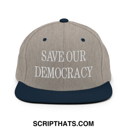 A gray and navy blue snapback hat with flat bill brim embroidered with save our democracy in white thread