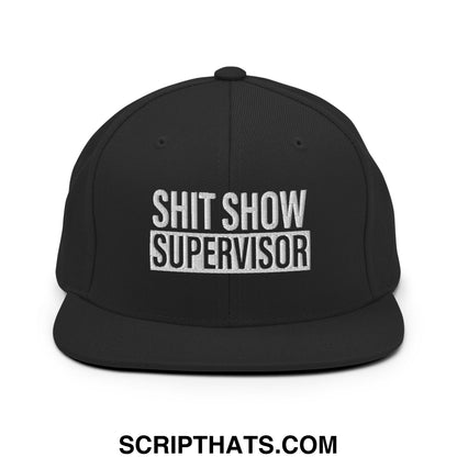 Black snapback cap with white embroidered shit show supervisor text and flat bill brim design