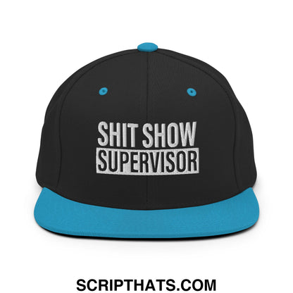 Black snapback hat with teal flat bill and button embroidered white text shit show supervisor in bold block letters