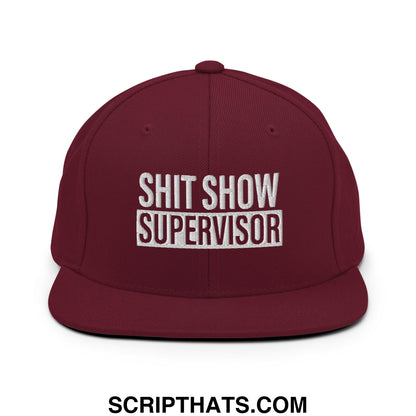 Maroon snapback hat with white embroidered shit show supervisor text and flat bill brim design