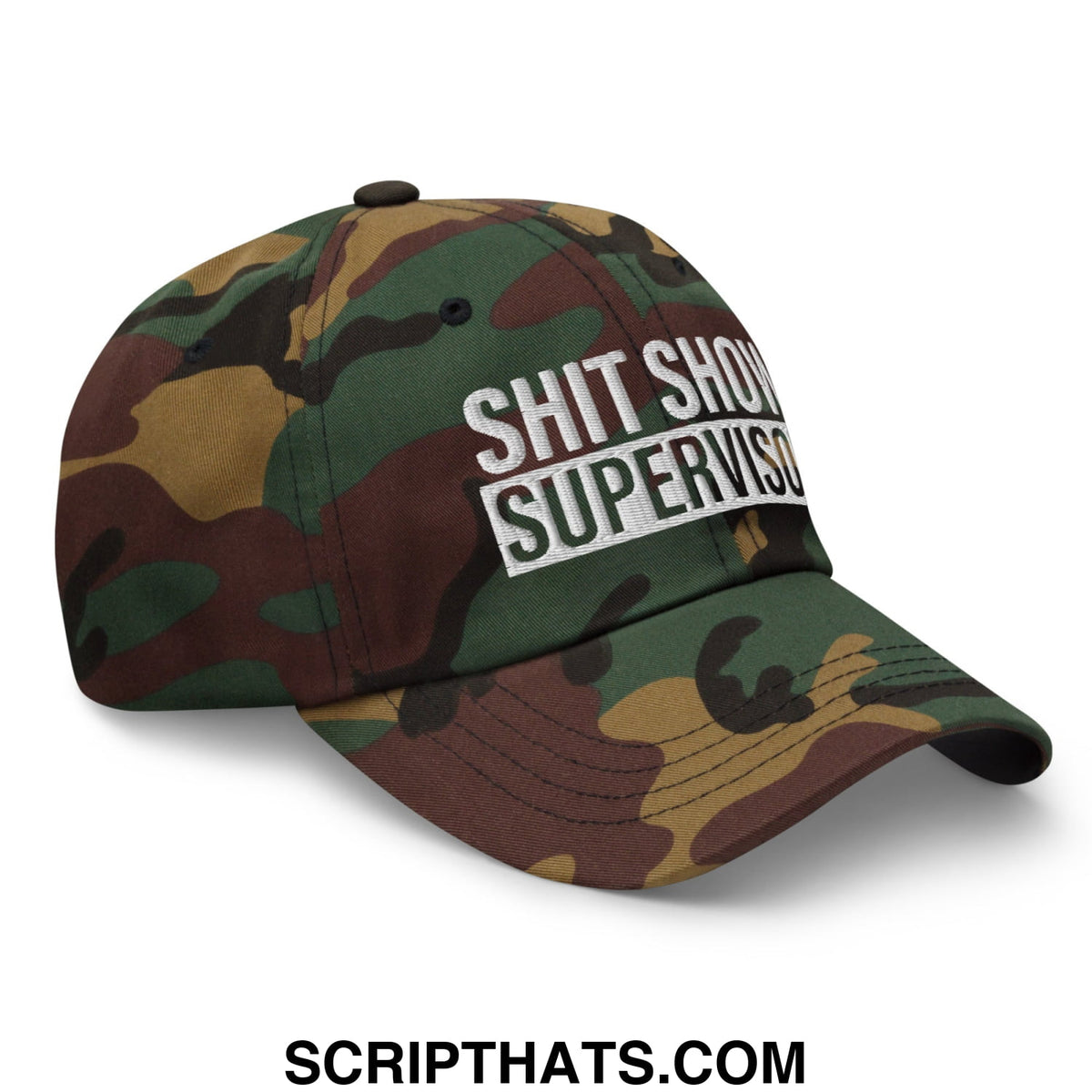 A camouflage-patterned unstructured dad hat with white embroidered shit show supervisor text on the front