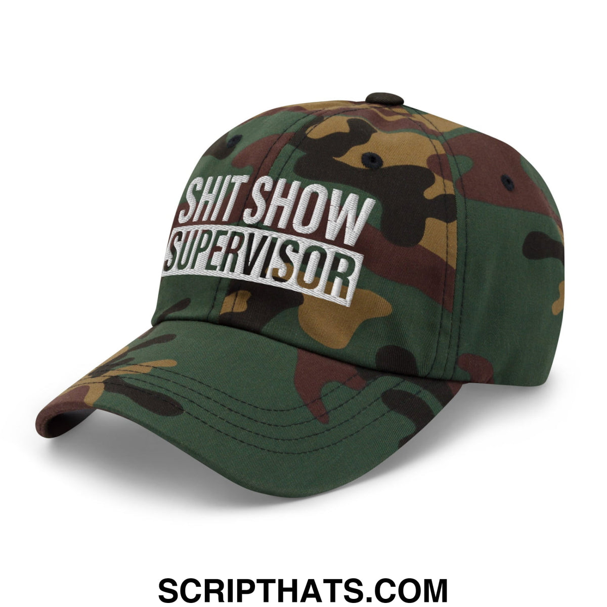 A camouflage unstructured dad hat with shit show supervisor embroidered in white and black lettering on the front