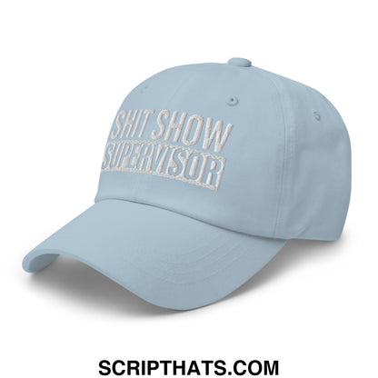 Light blue unstructured dad hat with shit show supervisor embroidered in silver thread on the front