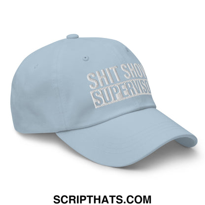 Light blue embroidered unstructured dad hat with white text reading shit show supervisor in a casual style