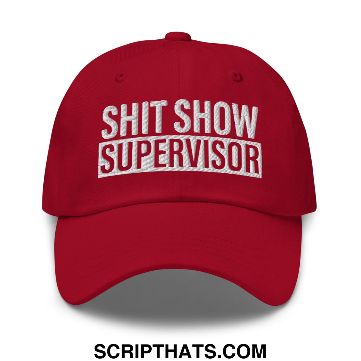 Red unstructured dad hat with shit show supervisor embroidered in white and red thread on the front
