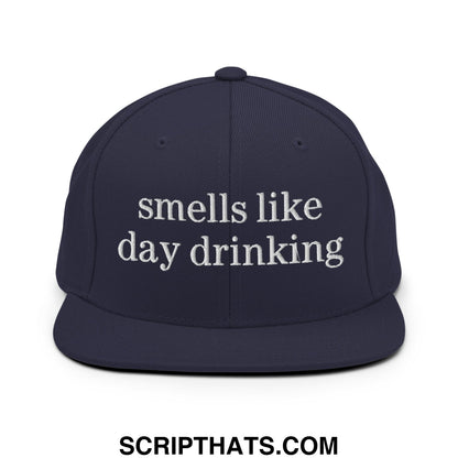 Navy blue snapback hat with white embroidered smells like day drinking text and flat bill brim design