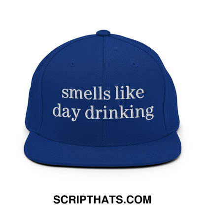 Royal blue snapback cap with white embroidered text smells like day drinking and flat bill brim design