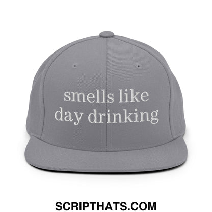 Gray snapback hat with white embroidered text reads smells like day drinking flat bill brim design