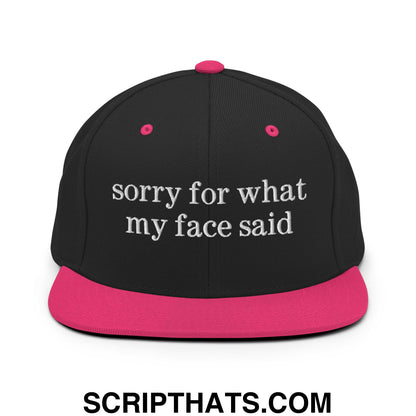Black snapback cap with vibrant pink brim and button featuring white embroidered sorry for what my face said text
