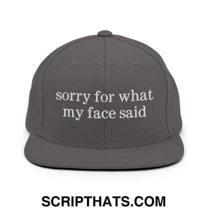 Dark gray flat bill snapback hat with white embroidered sorry for what my face said text on the front