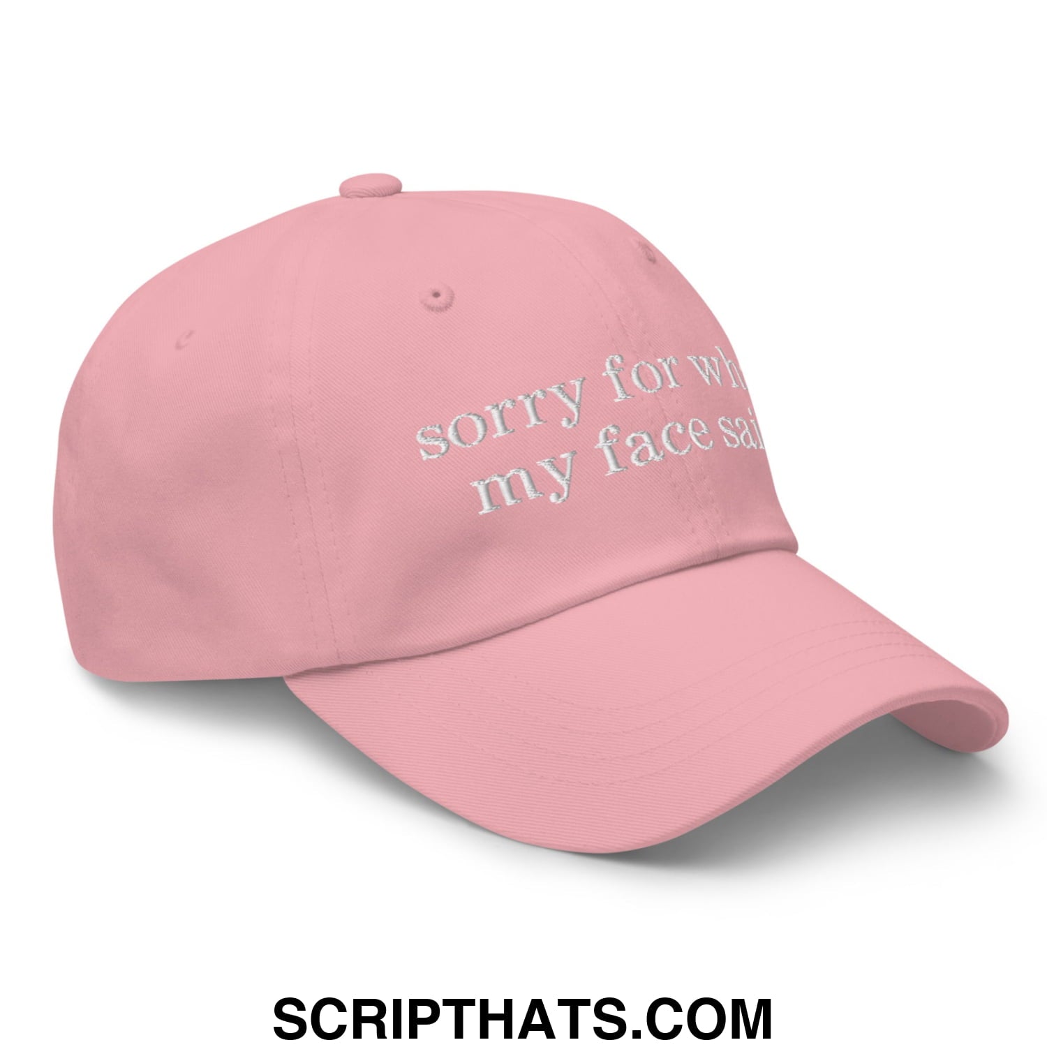 A soft pink unstructured dad hat with white embroidered sorry for what my face said text on the front