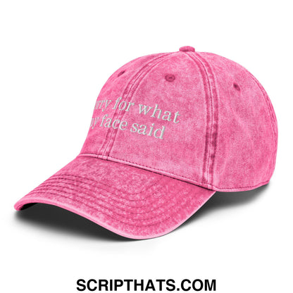 A faded pink unstructured denim dad hat with white embroidered text sorry for what my face said on the front