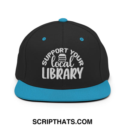 Black snapback hat with teal brim and button featuring white embroidered support your local library text and book icon