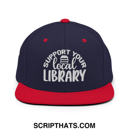 Navy blue and red snapback hat with white embroidered support your local library text and stack of books graphic