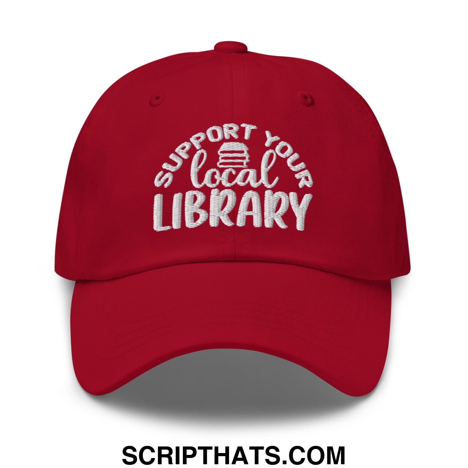 A red embroidered unstructured dad hat with support your local library text and a small stack of books icon above local