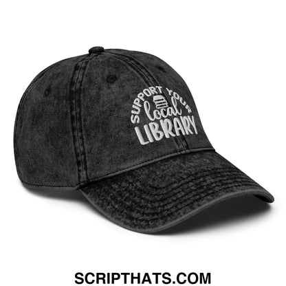 Black distressed denim dad hat with white embroidered support your local library text and a small book icon