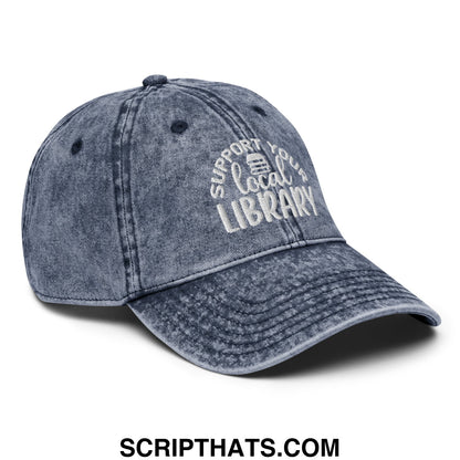 Faded blue denim dad hat with white embroidered support your local library text and small book icon