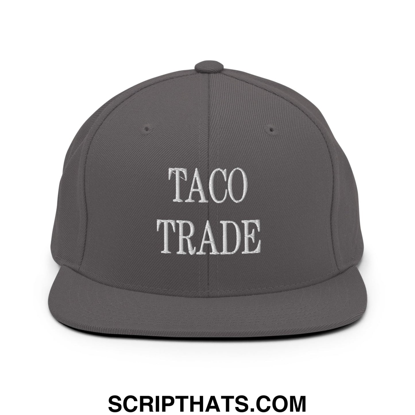 A dark gray snapback hat with taco trade embroidered in white thread on the front flat bill brim