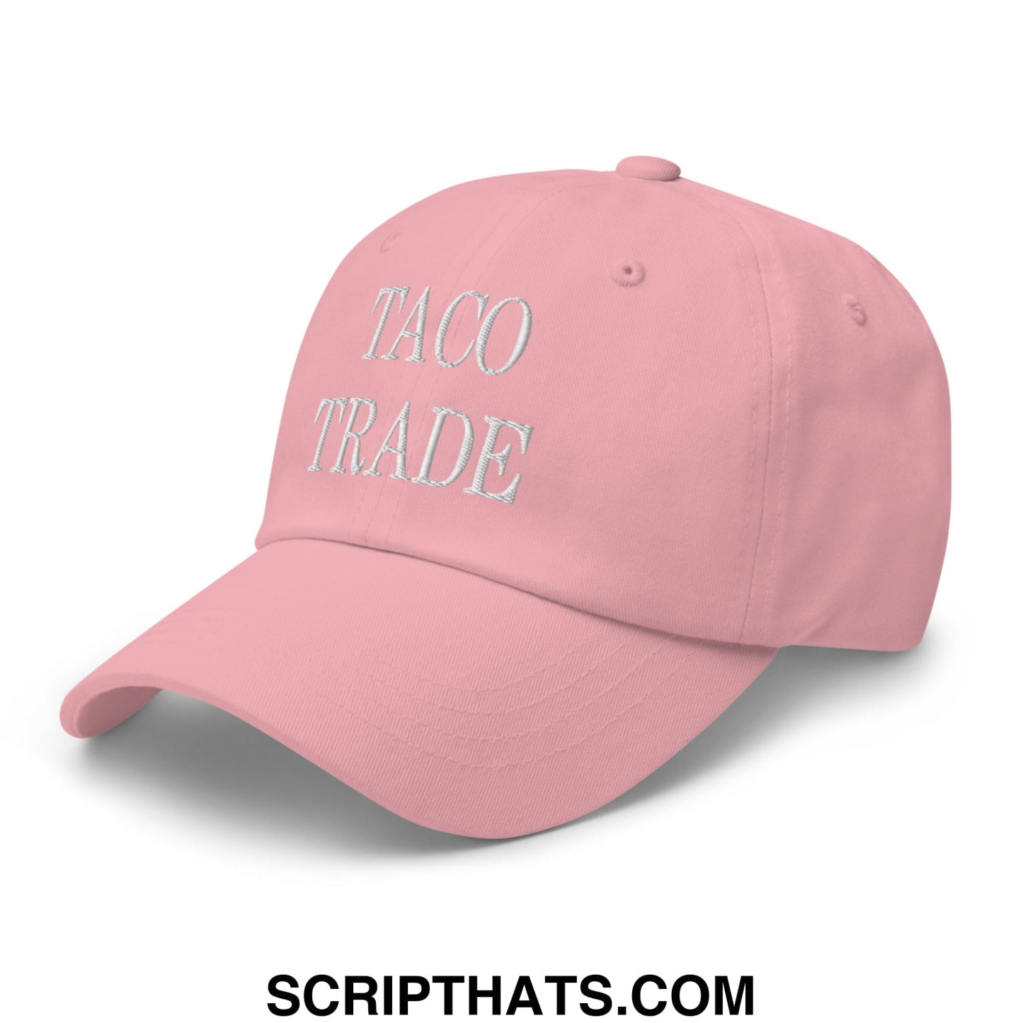 A soft pink unstructured dad hat with taco trade embroidered in subtle silver thread on the front